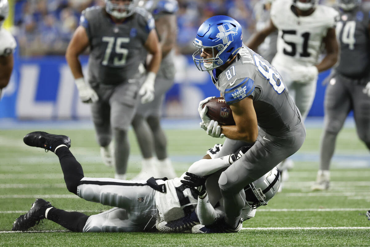 Detroit Lions tight end Sam LaPorta (87) is tackled by Las Vegas Raiders cornerback David Long ...