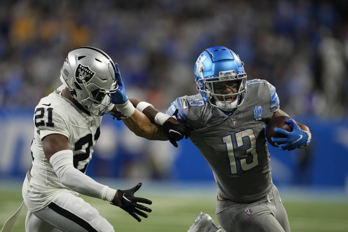 Detroit Lions running back Craig Reynolds (13) stiff arms Las Vegas Raiders cornerback Amik Rob ...