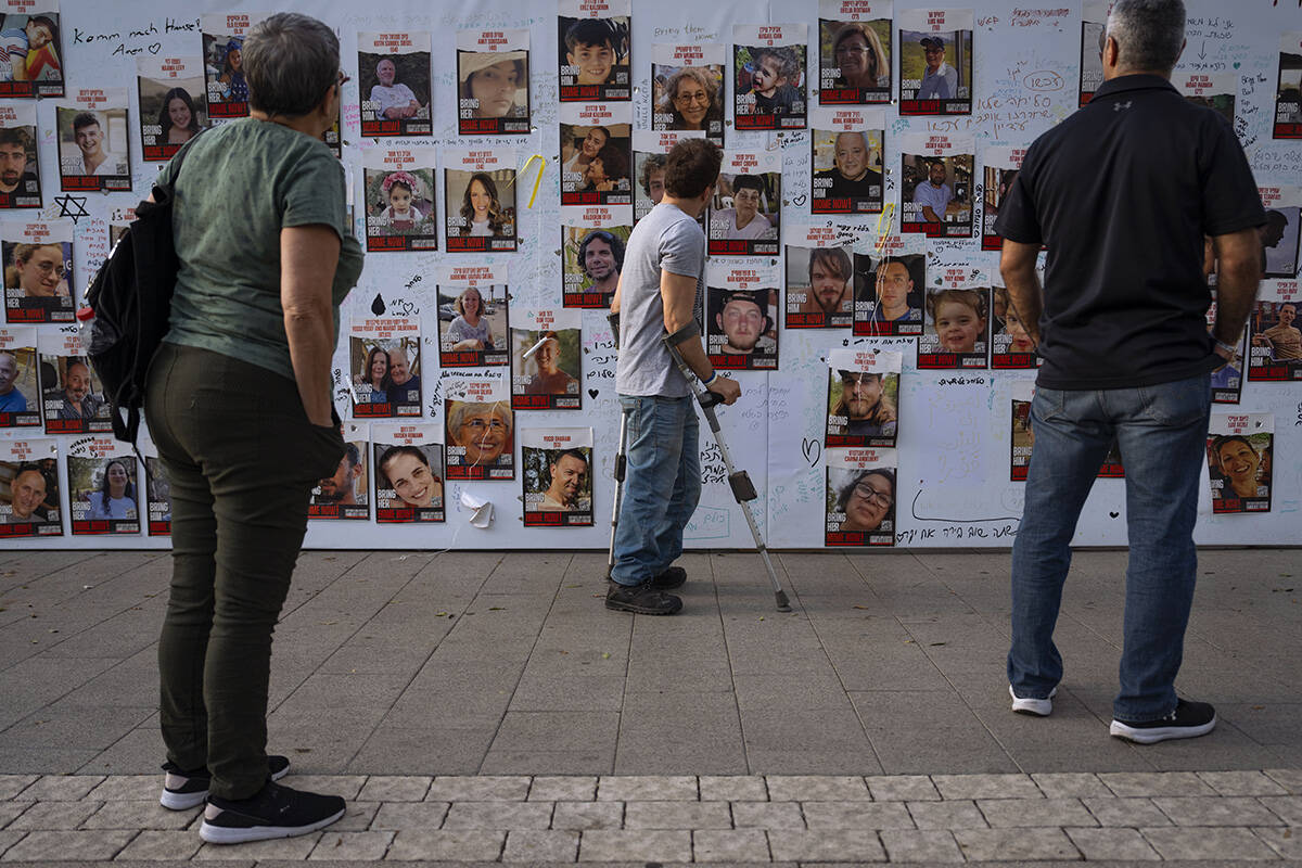 People look at photographs of hostages. mostly Israeli civilians who were abducted during the O ...