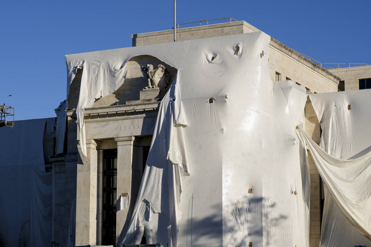 The sculpture of an eagle looks out from behind protective construction wrapping on the facade ...