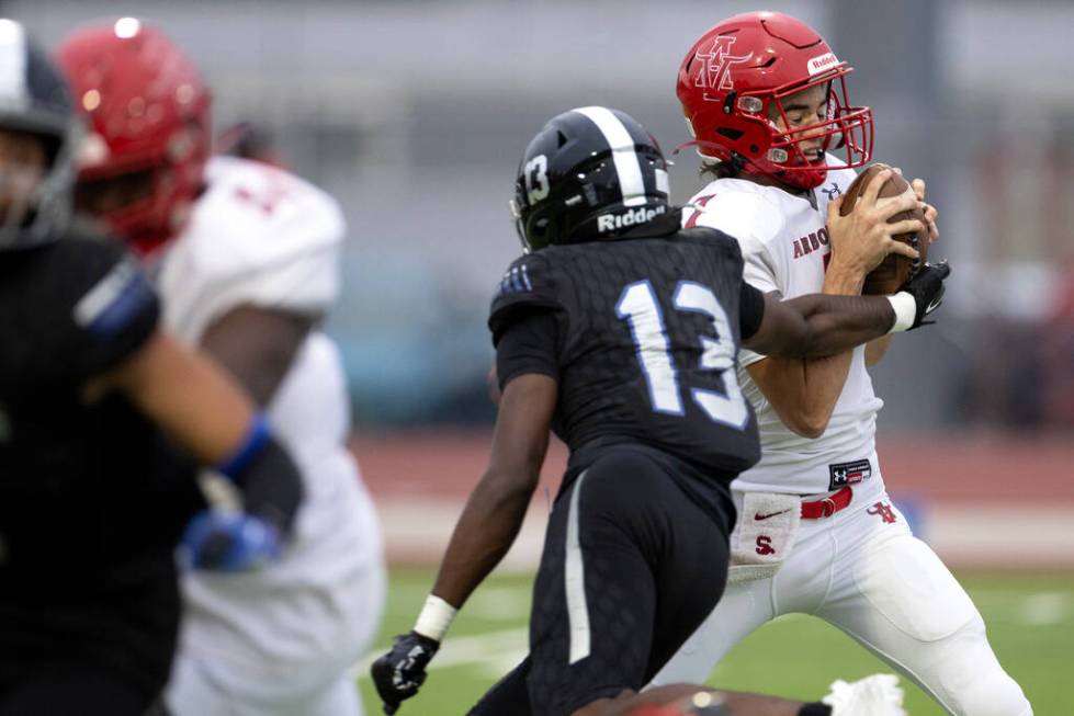 Arbor View quarterback Thaddeus Thatcher (7) is pressured by Desert Pines linebacker Se'Mauri N ...