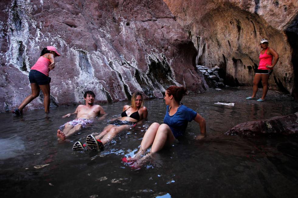 From left, Matt Fields, Gilliane Holt and Brooke Cannon relax in a hot springs pool above Arizo ...