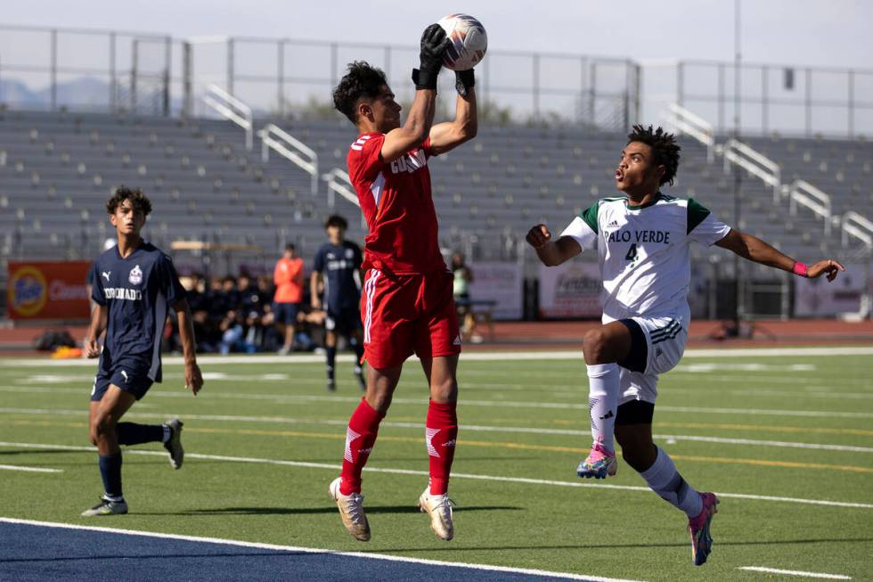 Palo Verde midfielder Ajani Smith (4) follows through on his shot while Coronado goaltender Log ...