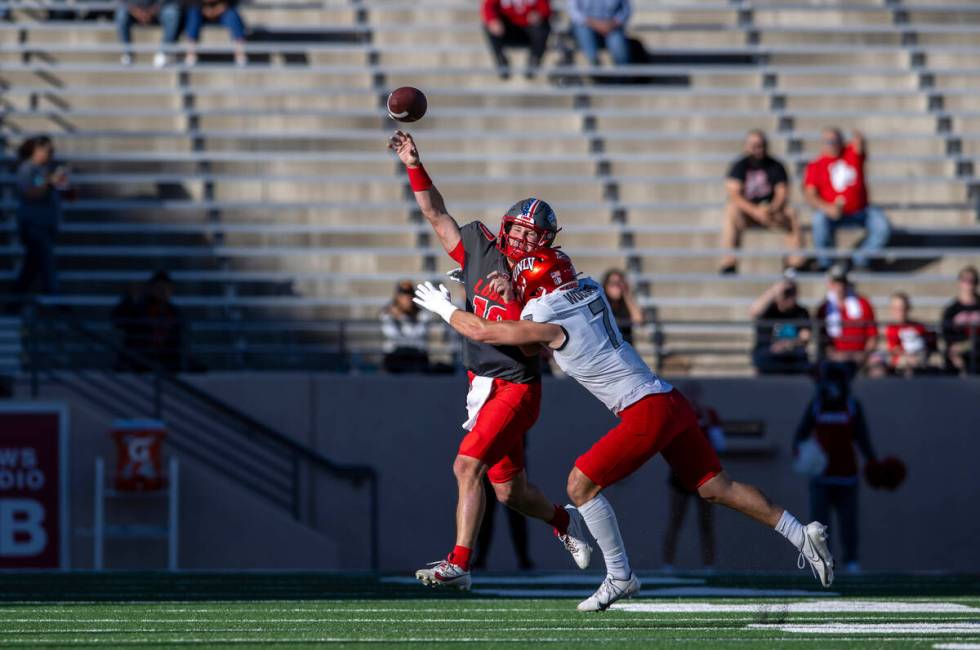 UNM's quarterback Dylan Hopkins gets rid of the ball before being hit by UNLV's Jackson Woodard ...