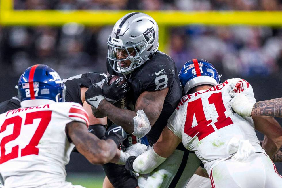 Raiders running back Josh Jacobs (8) battles for more yards against New York Giants linebacker ...