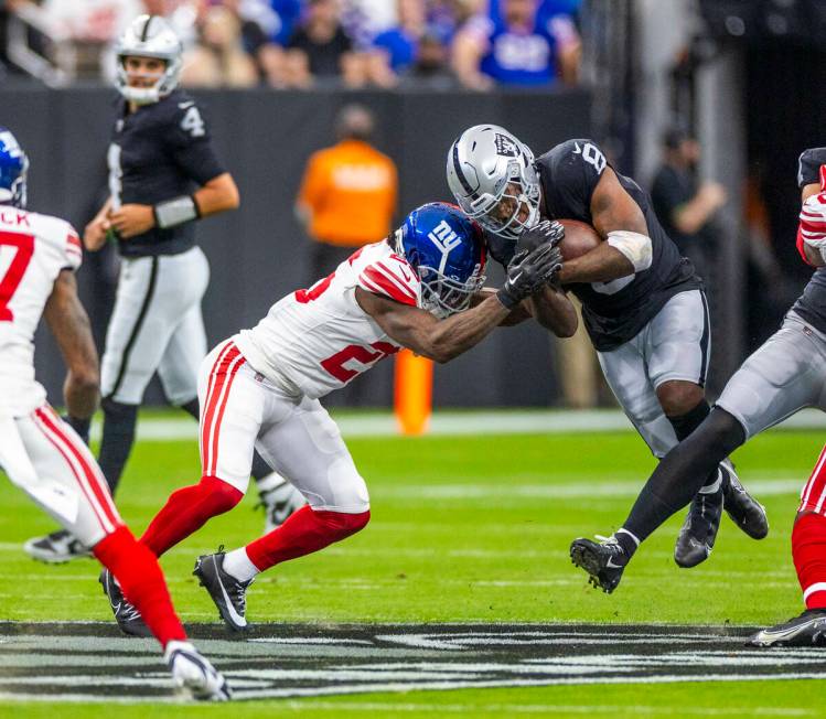 Raiders running back Josh Jacobs (8) takes on New York Giants cornerback Deonte Banks (25) duri ...