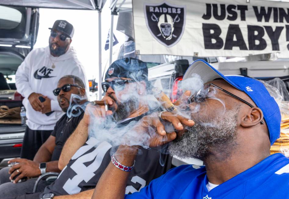 Fans enjoy cigars in the tailgating area before the start of the Raiders against the New York G ...