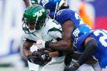 New York Jets wide receiver Garrett Wilson (17) runs the ball during the first half of an NFL f ...