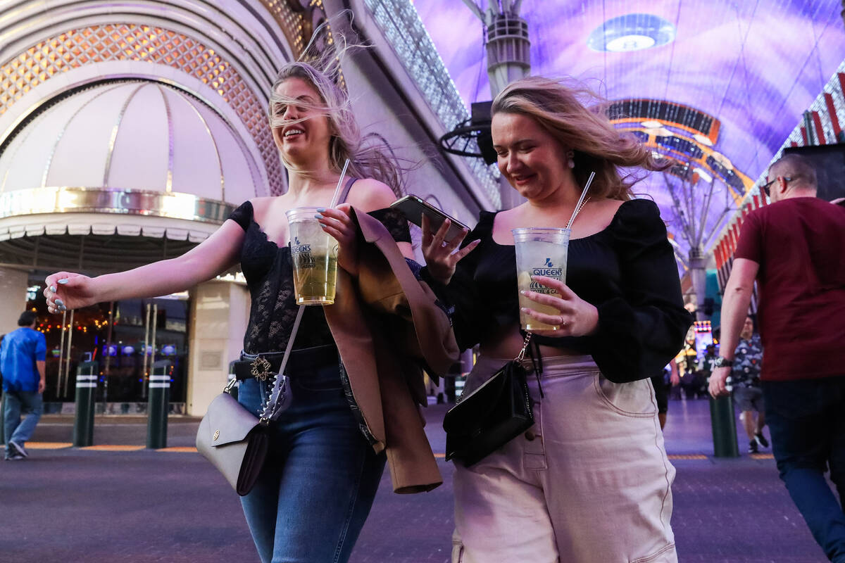 Tourists battle through the wind along Fremont Street on Monday, Nov. 6, 2023 in Las Vegas. (Da ...