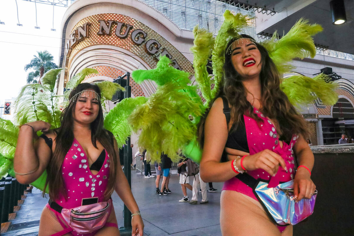 Showgirls battle through the wind along Fremont Street on Monday, Nov. 6, 2023 in Las Vegas. (D ...