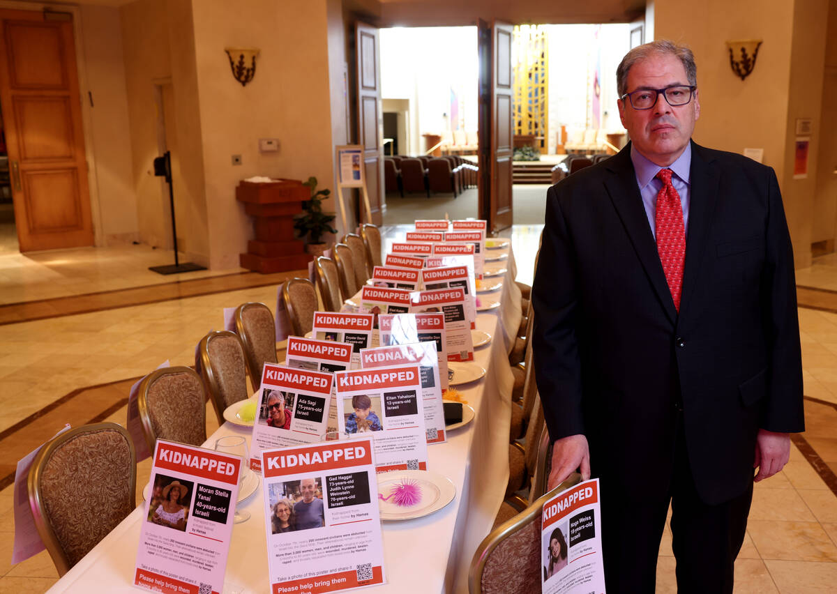 Rabbi Felipe Goodman poses with a Shabbat table dedicated to people kidnapped during the Oct. 7 ...