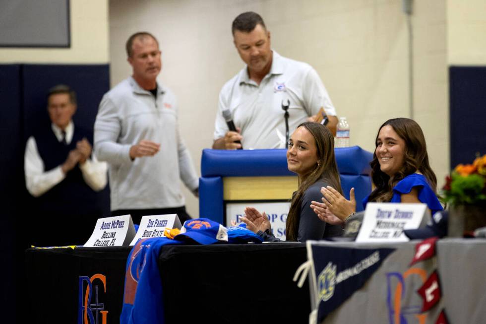Lacrosse player Addie McPhee, left, and golfer Zoe Parker, right, clap before signing their nat ...