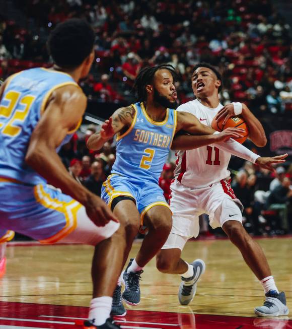 UNLV guard Dedan Thomas Jr. (11) struggles to keep the ball as Southern guard Antoine Jacks (2) ...