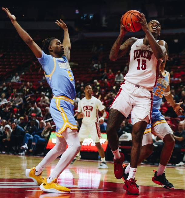 UNLV guard Luis Rodriguez (15) attempts a shot as Southern guard Jordan Mitchell (9) guards him ...