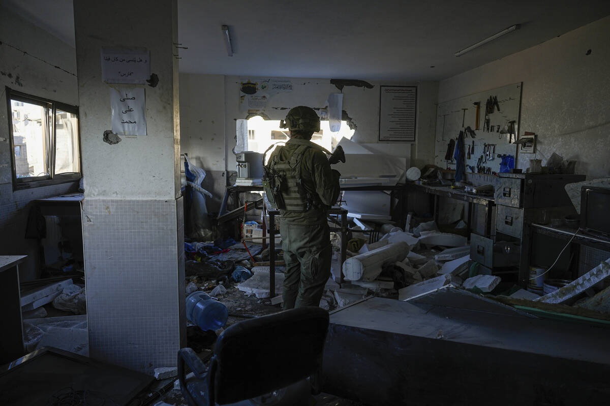 An Israeli soldier stands in what the army says was a Hamas weapons-making facility during a gr ...