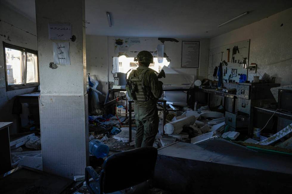 An Israeli soldier stands in what the army says was a Hamas weapons-making facility during a gr ...