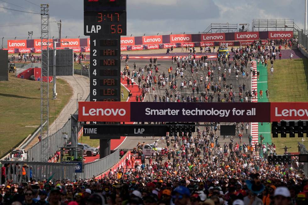 Fans walk on the track after the the Formula One U.S. Grand Prix auto race at Circuit of the Am ...