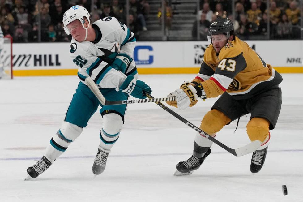 San Jose Sharks left wing Fabian Zetterlund (20) passes around Vegas Golden Knights center Paul ...