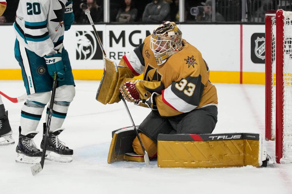 Vegas Golden Knights goaltender Adin Hill (33) makes a save beside San Jose Sharks left wing Fa ...