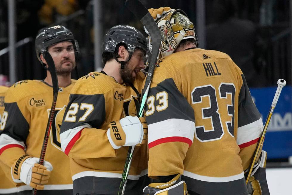 Vegas Golden Knights defenseman Shea Theodore (27) and goaltender Adin Hill (33) celebrate afte ...