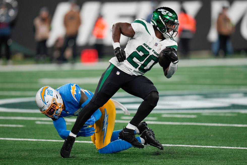 New York Jets running back Breece Hall (20) breaks away from Los Angeles Chargers safety Dean M ...