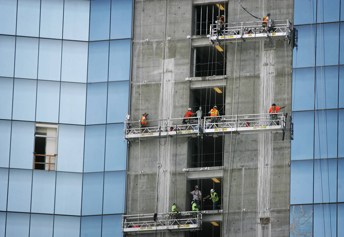 Construction workers hang above the Strip while trying to finish the Fontainebleau on April 24, ...