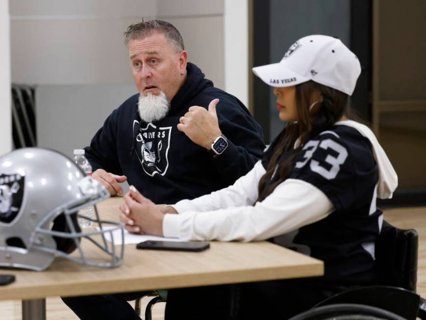 Raiders wheelchair football team head coach Bob Murray speaks as Beya Tep looks on during an in ...