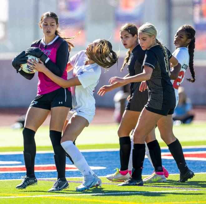 Faith Lutheran goalkeeper Demi Gronauer (01) keeps the ball from Coronado defender Mia Schlacht ...