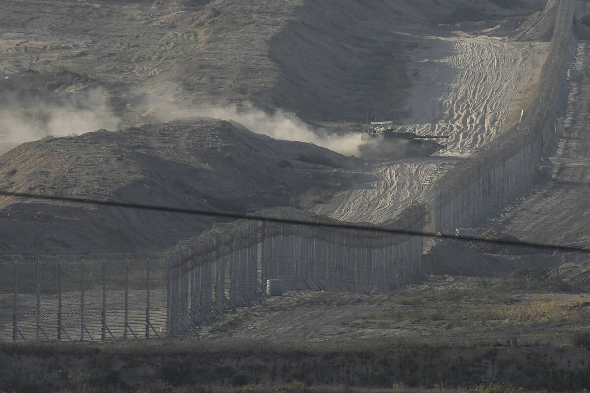 An Israeli tank manoeuvres in the Gaza Strip, as seen from southern Israel, Friday, Nov. 10, 20 ...