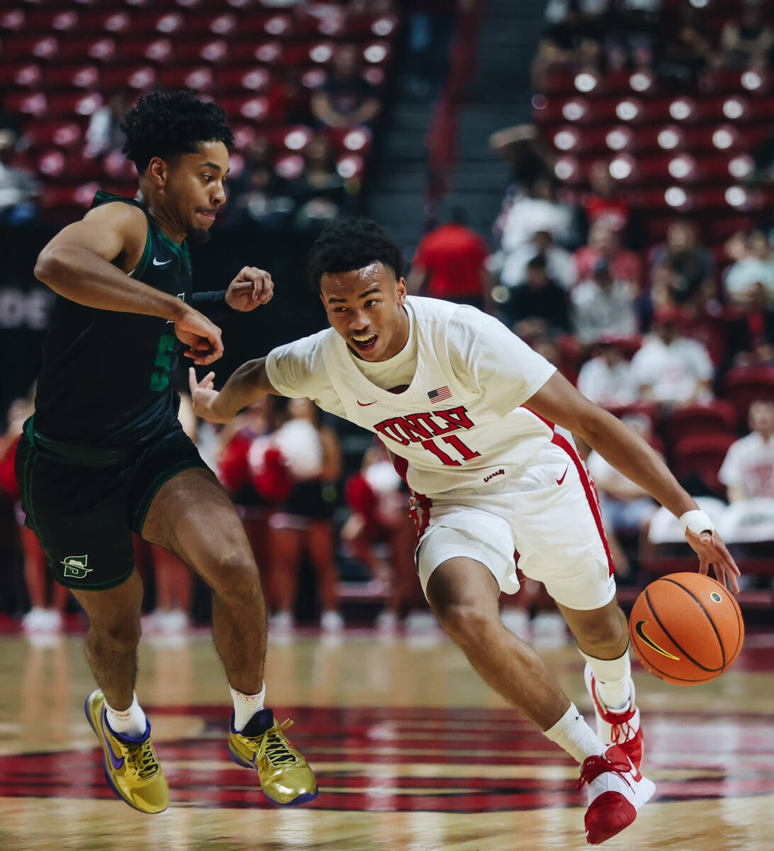 UNLV guard Dedan Thomas Jr. (11) dribbles the ball past Stetson guard Jalen Blackmon (5) during ...