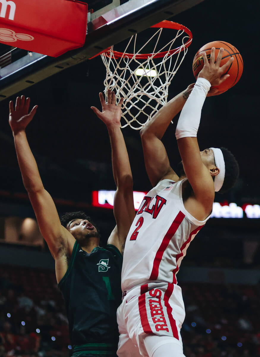 UNLV guard Justin Webster (2) reaches for a basket as Stetson guard Tristan Gross (1) jumps up ...