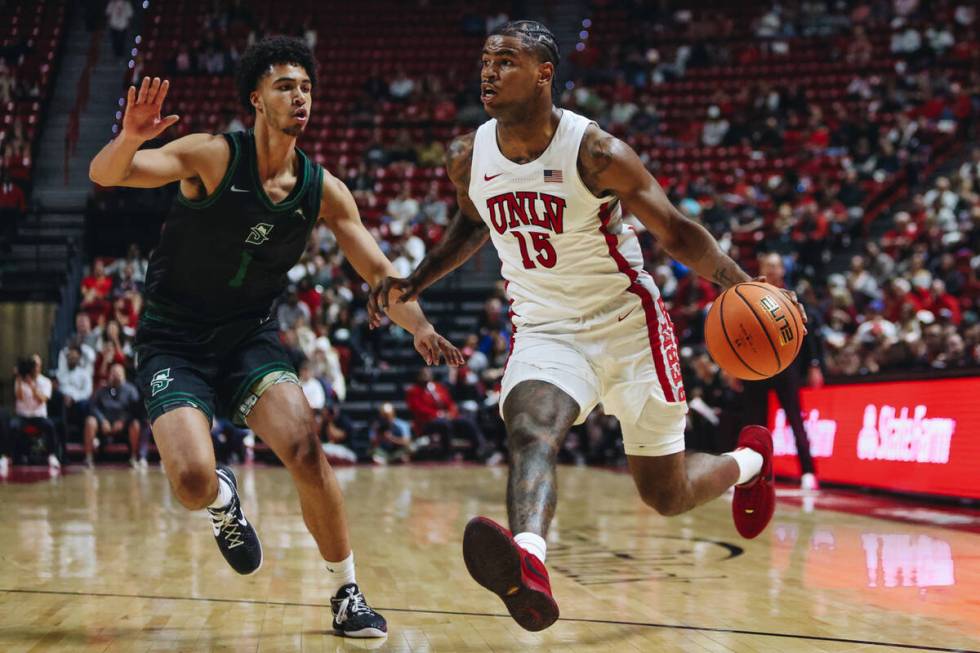 UNLV guard Luis Rodriguez (15) dribbles the ball as Stetson guard Tristan Gross (1) guards him ...