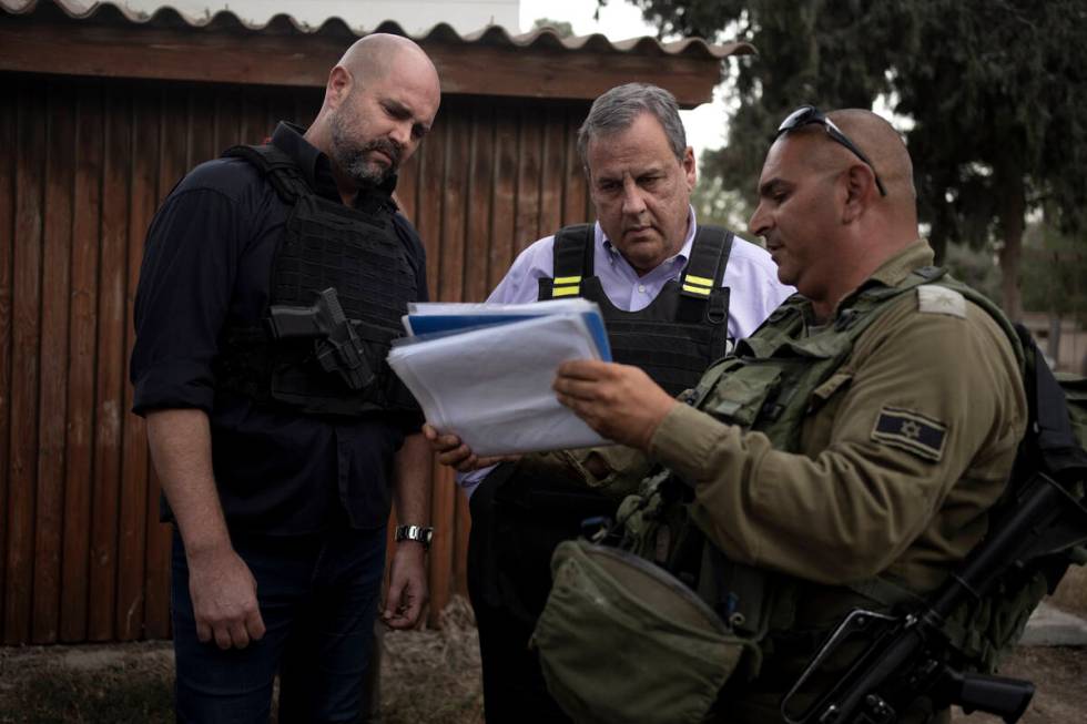 Former New Jersey Governor Chris Christie, center, looks at crime scene photos as he visits Kib ...