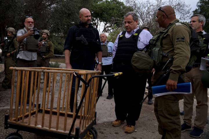 Former New Jersey Governor Chris Christie, center right, looks at a baby carriage as he visits ...