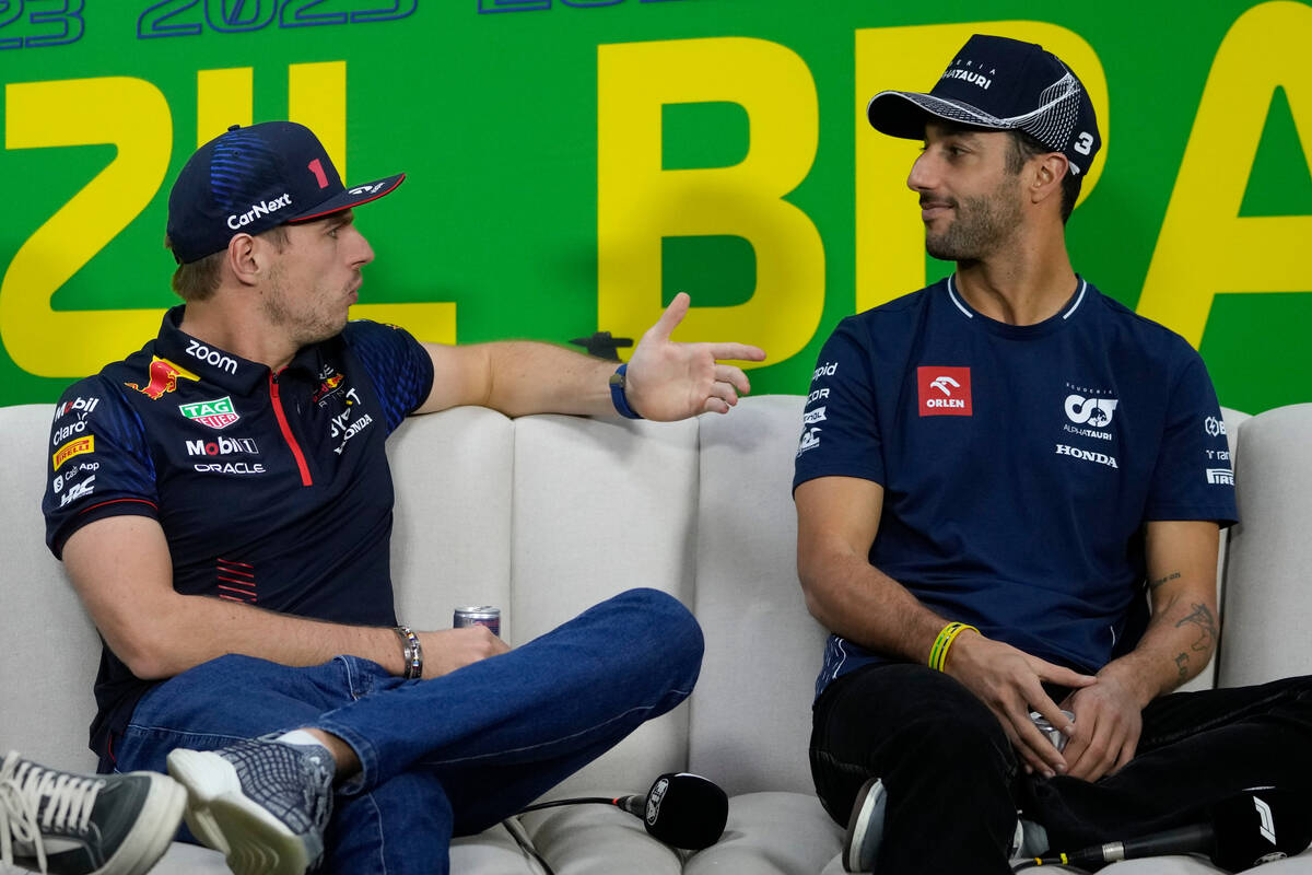 Red Bull driver Max Verstappen, of the Netherlands, left, talks with AlphaTauri driver Daniel R ...