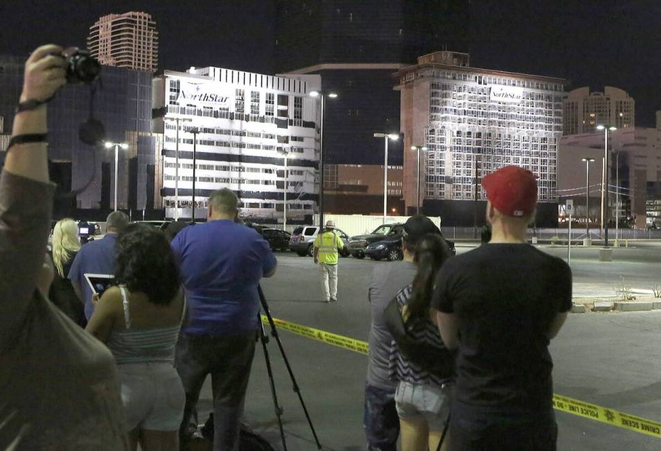 People gather on Sands Avenue to watch the final tower of the Riviera hotel-casino implosion on ...