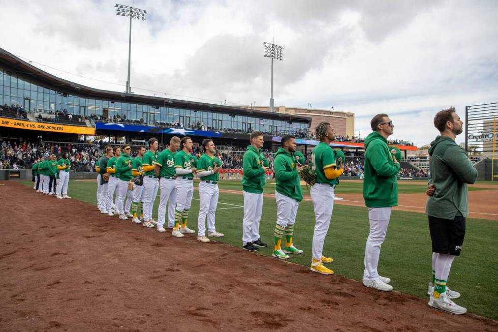 The Oakland Athletics remove their ball caps for the national anthem before a baseball game aga ...