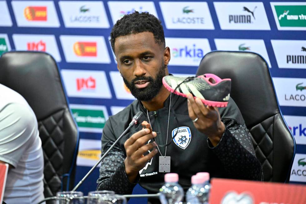 Israel team captain Eli Dasa shows a shoe of a kidnapped Israeli boy during a press conference, ...