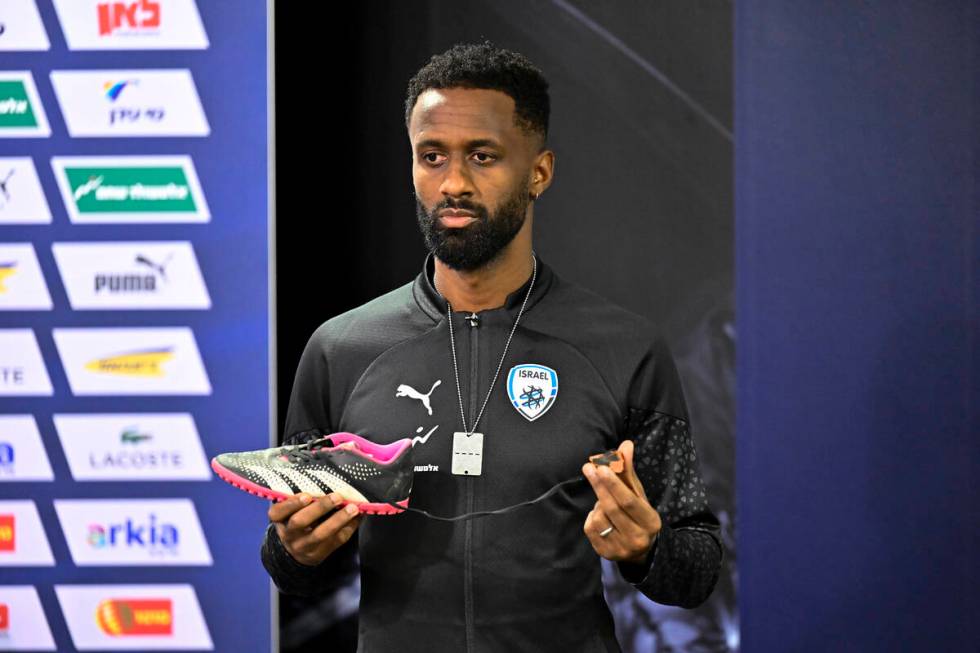 Israel team captain Eli Dasa shows a shoe of a kidnapped Israeli boy during a press conference, ...