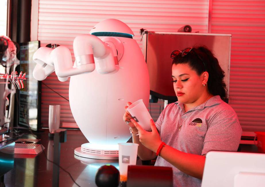 Paola Valdez first takes customer’s orders then passes a cup to Adam the robot who then ...