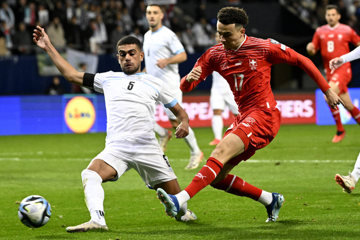 Israel's Raz Shlomo, left, tries to block Switzerland's Ruben Vargas during the Euro 2024 group ...