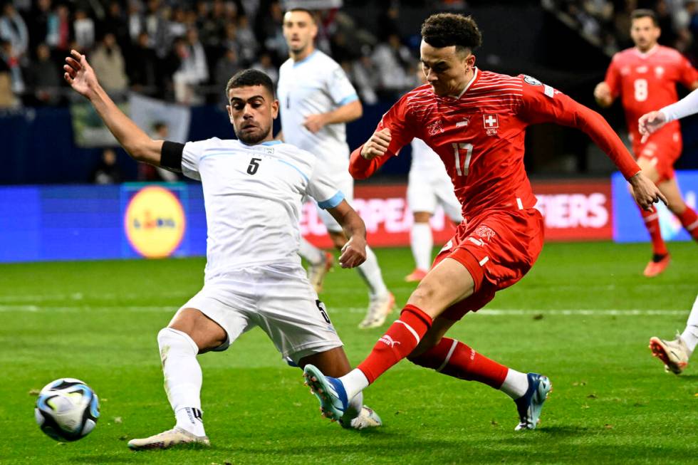 Israel's Raz Shlomo, left, tries to block Switzerland's Ruben Vargas during the Euro 2024 group ...