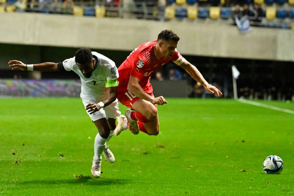 Israel's Eli Dasa, left, challenges Switzerland's Granit Xhaka during the Euro 2024 group I qua ...