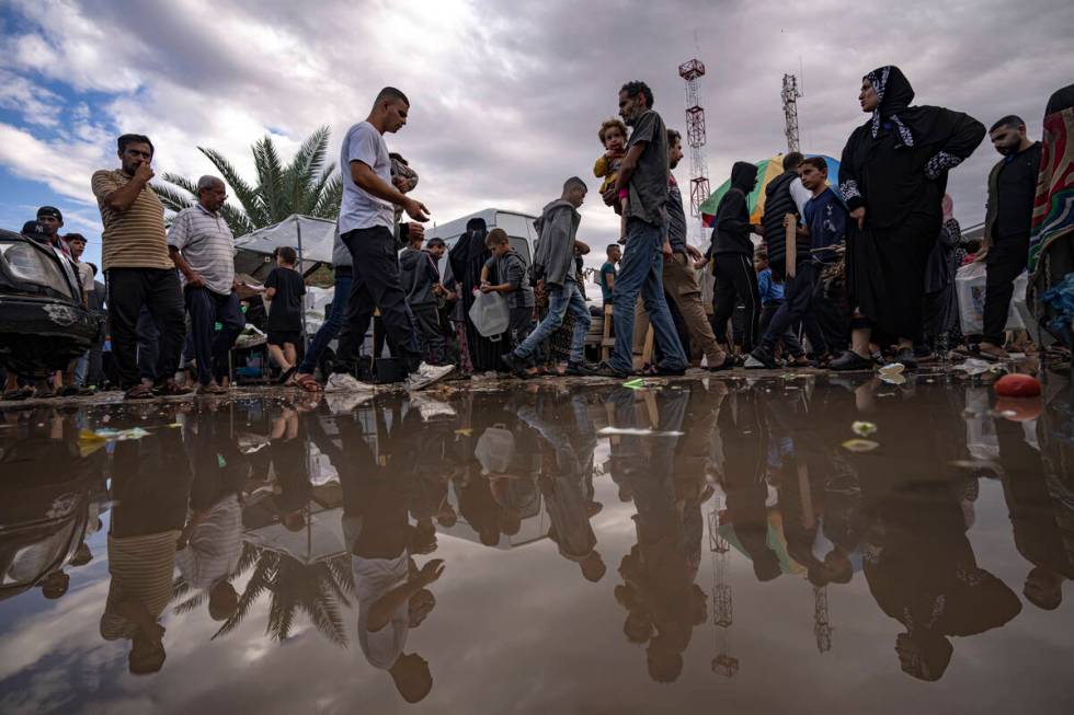 Palestinians displaced by the Israeli bombardment of the Gaza Strip walk in a UNDP-provided ten ...