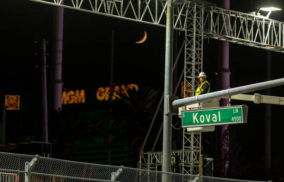 A race crewman works on lights along the track before practice time begins during the opening n ...