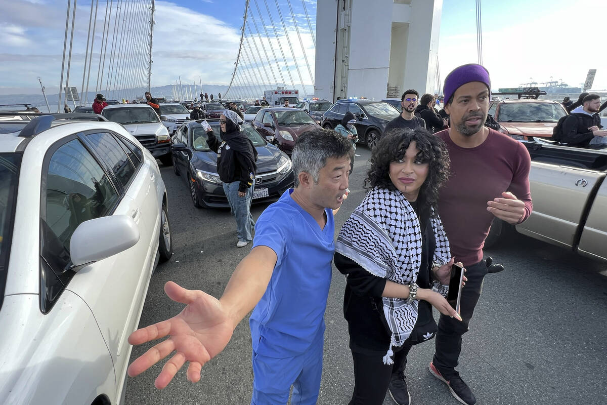 Dr. George Tanaka, left, an eye surgeon, joins demonstrators as they shut down the San Francisc ...