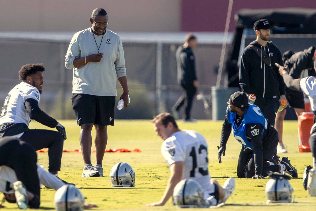 Raiders defensive coordinator Patrick Graham, standing left, walks through practice at the Inte ...