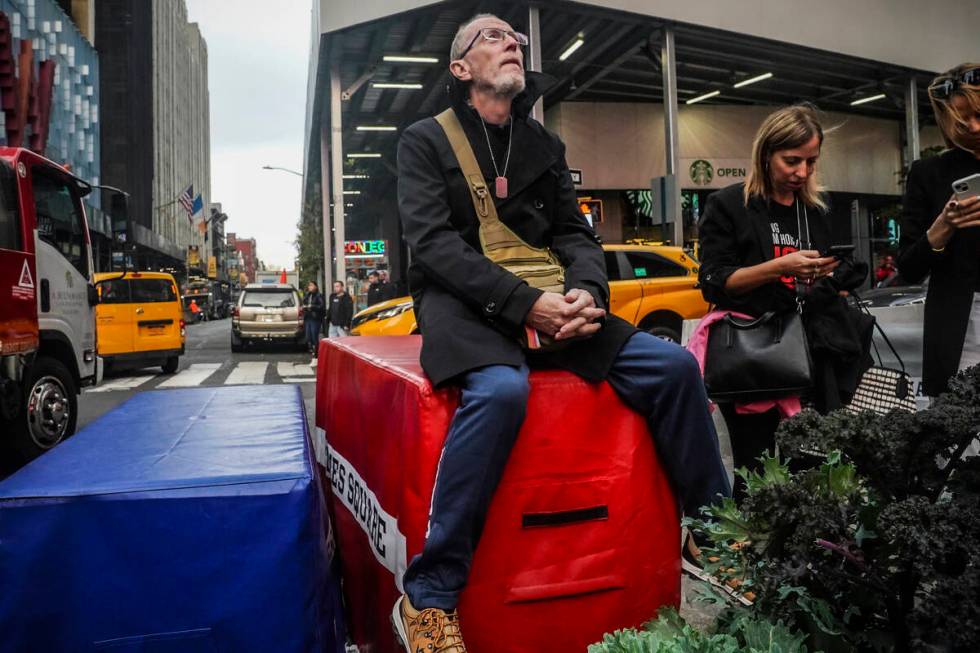 Thomas Hand, 63, looks up at a Times Square digital billboard where a poster of his daughter Em ...