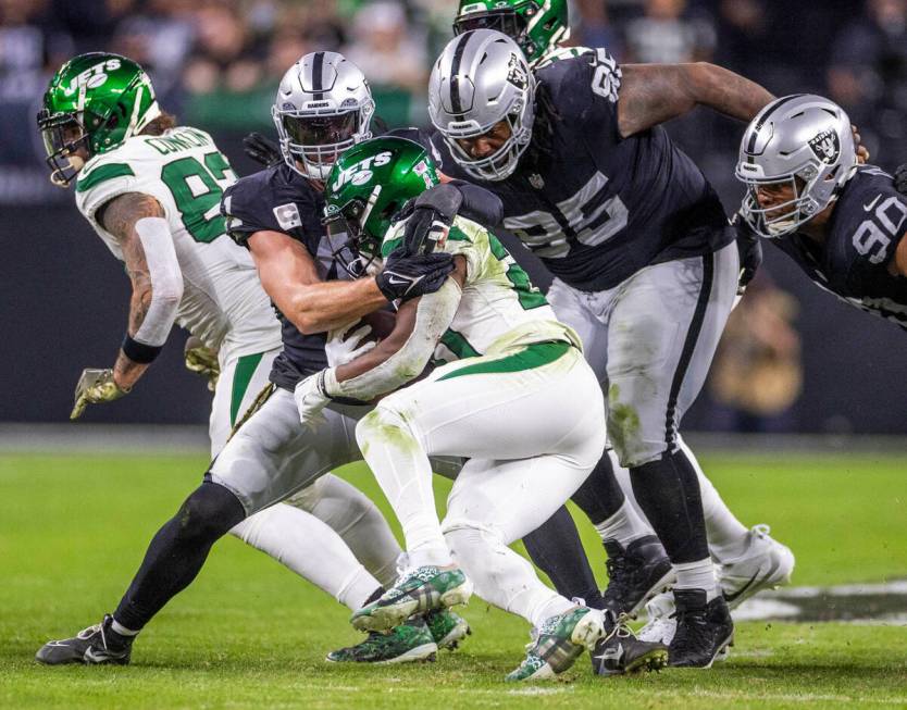 Raiders linebacker Robert Spillane (41) and defensive tackle John Jenkins (95) team up to tackl ...