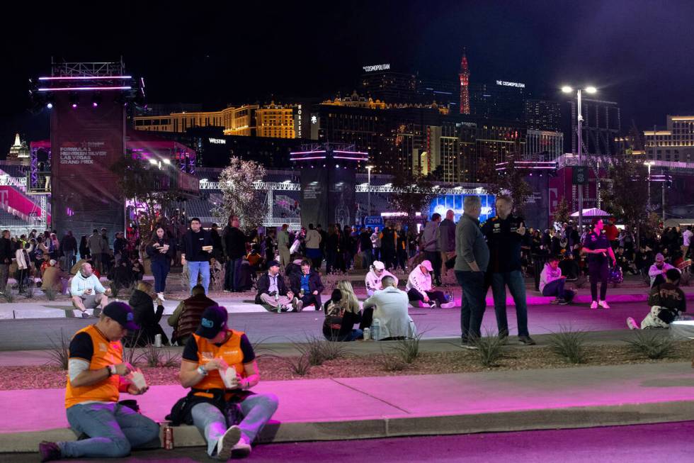 Fans sit on curbs at the Sphere fan zone before the third practice for the Formula One Las Vega ...